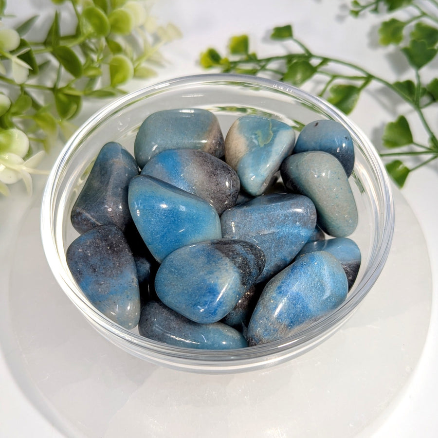 Blue and gray polished trolleite tumbled stones 0.9 to 1.5 inches displayed in a clear glass bowl
