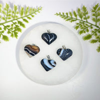 Four tuxedo agate 1 inch mini heart pendant charms with swirling black white blue and brown gemstones for jewelry