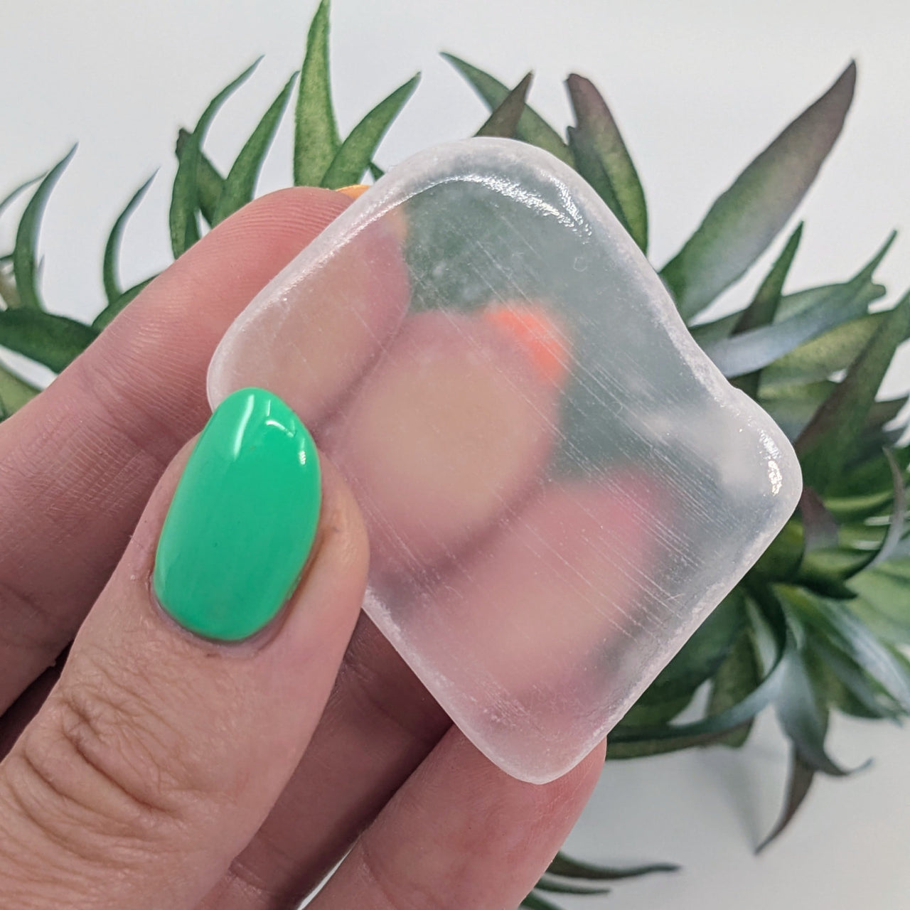 Clear silicone menstrual cup with mint green nails, showcasing Ulexite product features