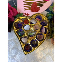 Valentines crystal candy box with gold heart filled with polished gemstones in purple paper