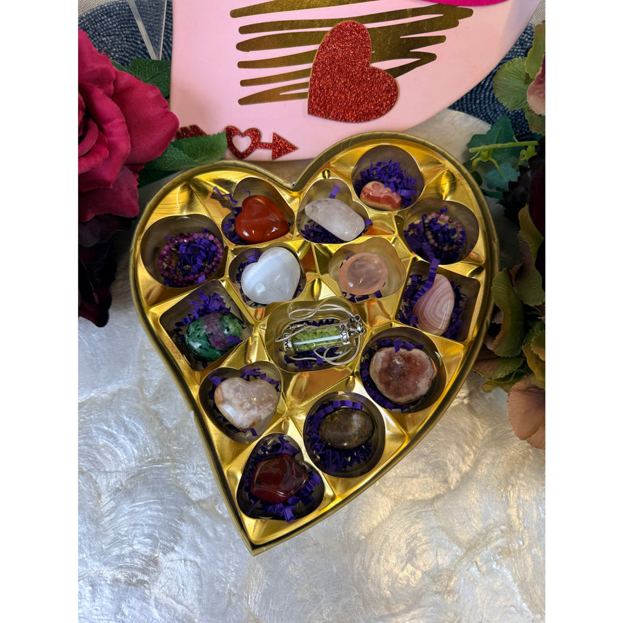 Valentines crystal candy box with gold heart filled with polished gemstones in purple paper