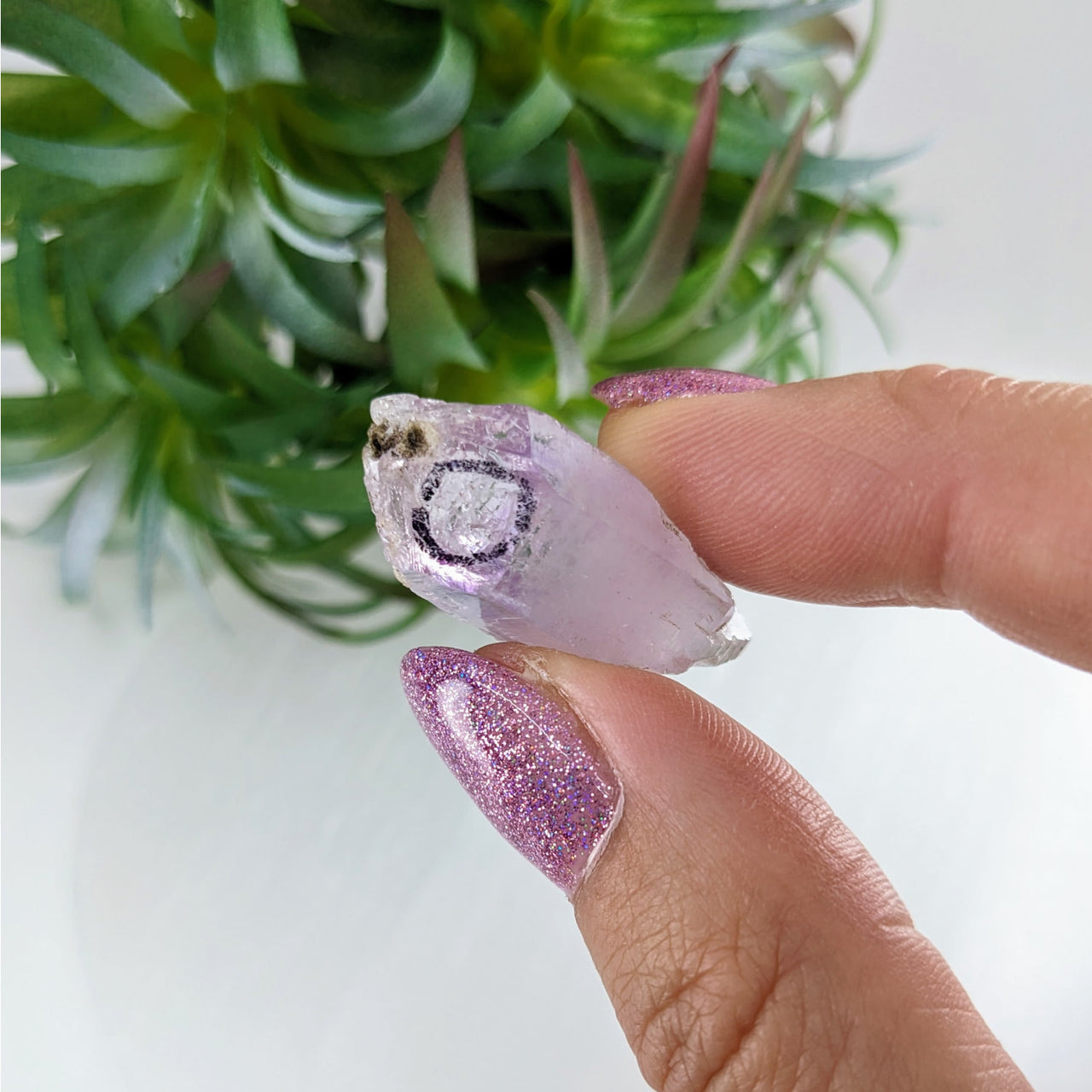 Person holding a purple and white glitter ring from Veracruz Amethyst 1.1’ Enhydro Point #LV3388