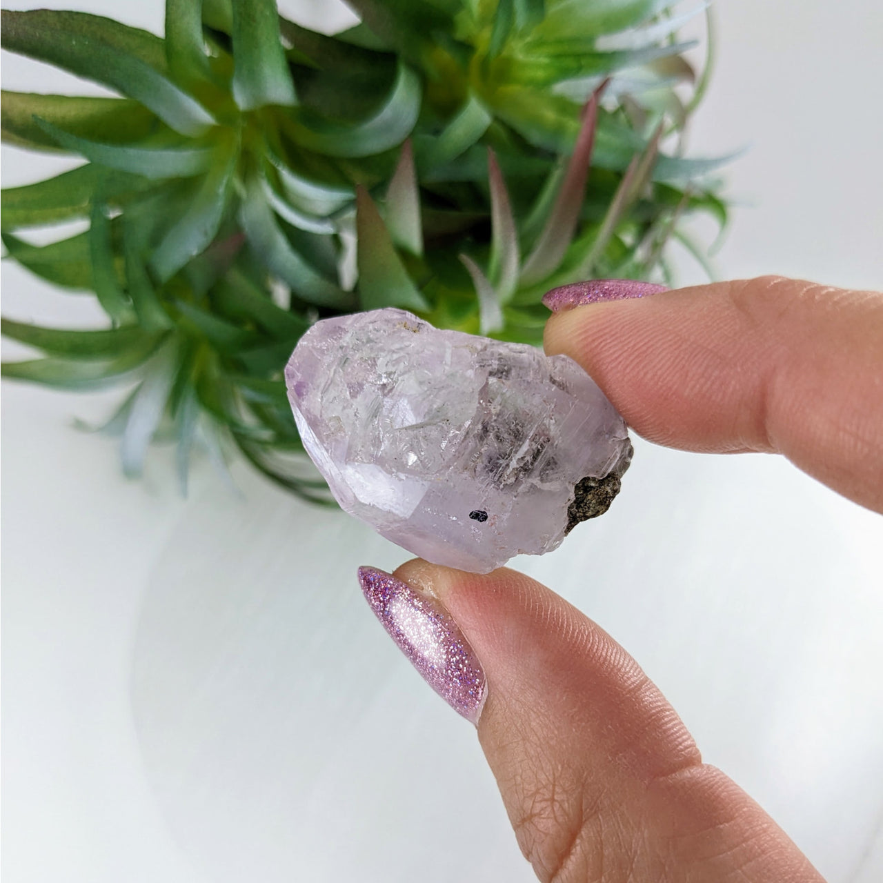 Person holding Veracruz Amethyst Enhydro Point; large purple quartz stone in hand