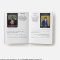 Open book of the wednesday official oracle deck displaying tarot cards obsession and avoidance with crystal-inspired art