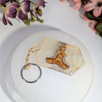 Clear resin meditating figure keychain with floral patterns, 4.5’’ mushroom design