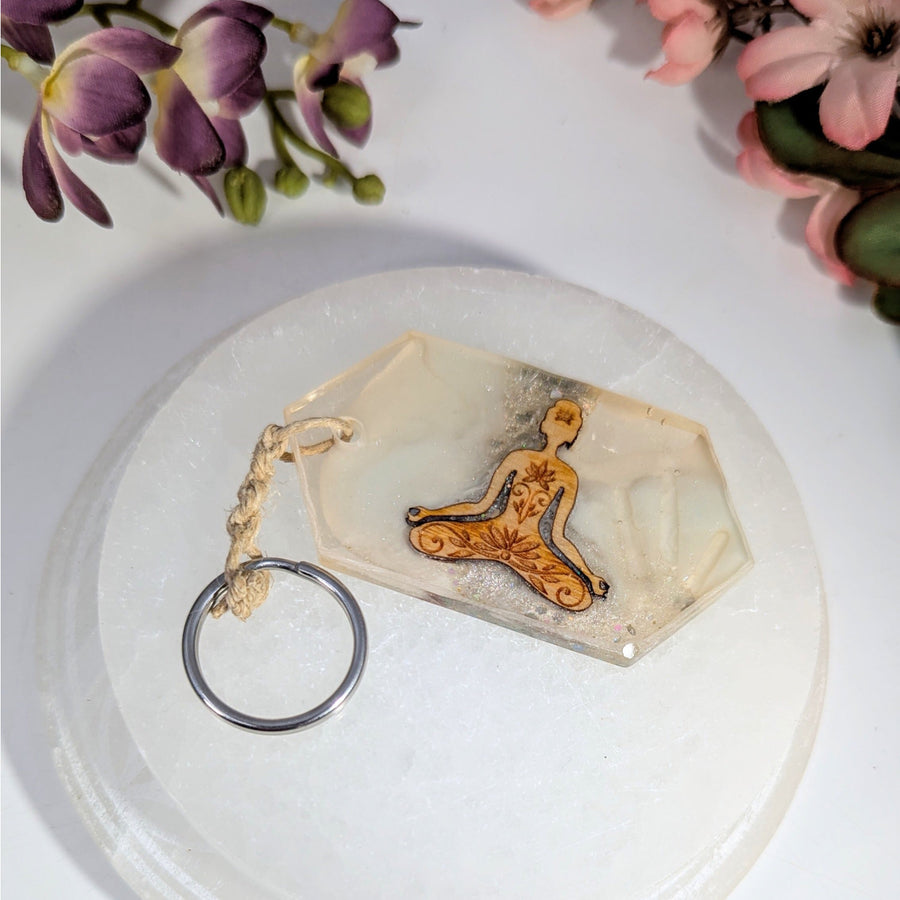 Clear resin meditating figure keychain with floral patterns, 4.5’’ mushroom design