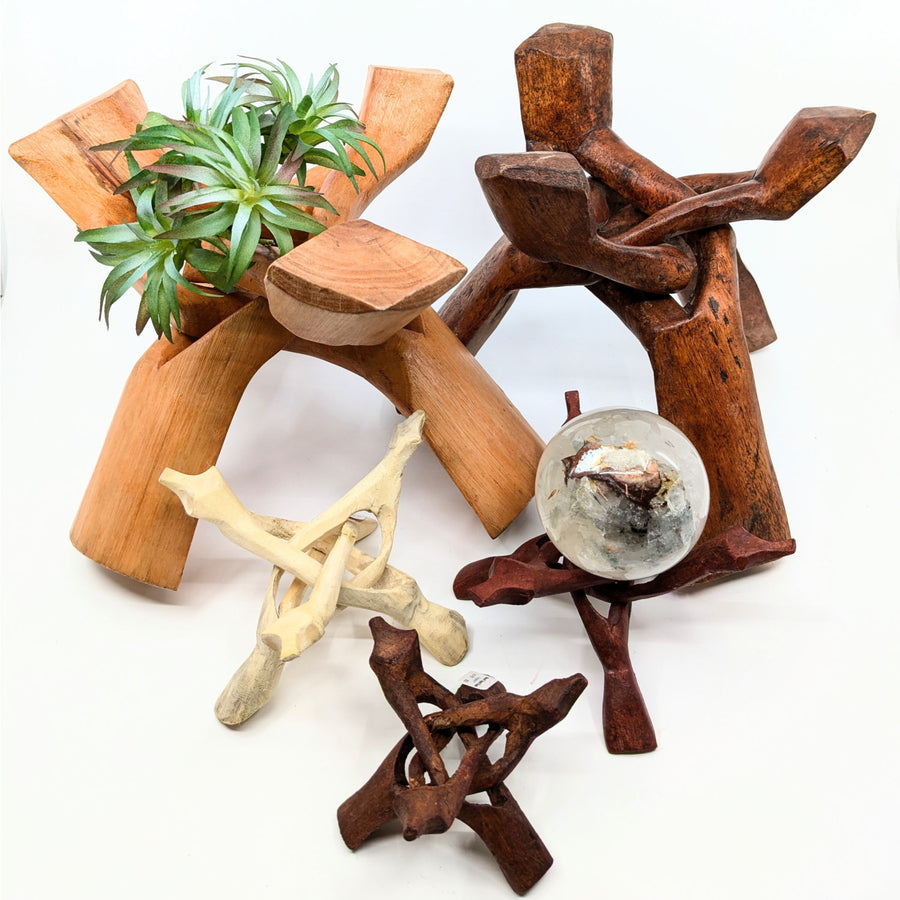 Assorted wooden stands and decorative objects showcasing a wood tripod stand holding abalone shell