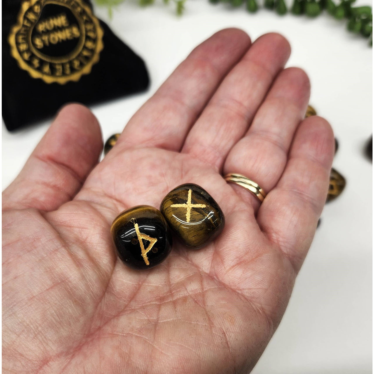 Two Tiger’s Eye rune stones from Yellow Tiger’s Eye Gemstone Rune Sets with Velvet Pouch
