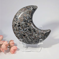 Yooperlite 3.9-inch gray moon-shaped stone with black speckles on acrylic stand