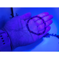 Purple UV-reactive Yooperlite beaded bracelet, 4mm glossy finish
