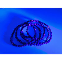 Purple Yooperlite 4mm UV-reactive stretch bracelet with black accents