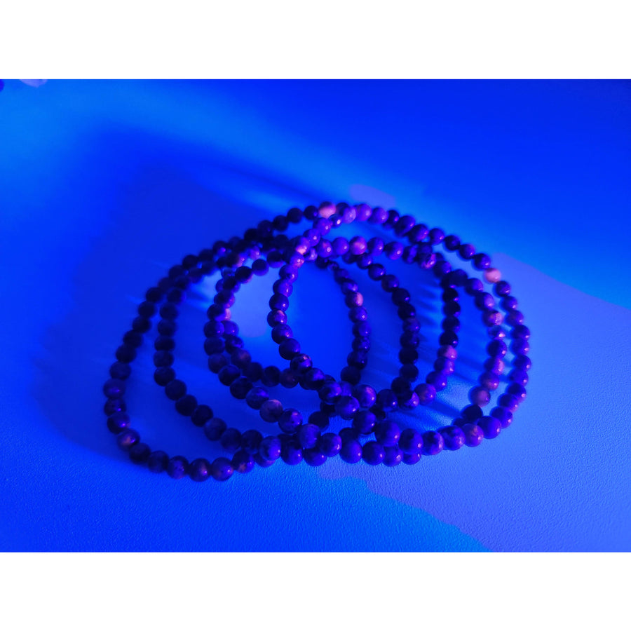 Purple Yooperlite 4mm UV-reactive stretch bracelet with black accents