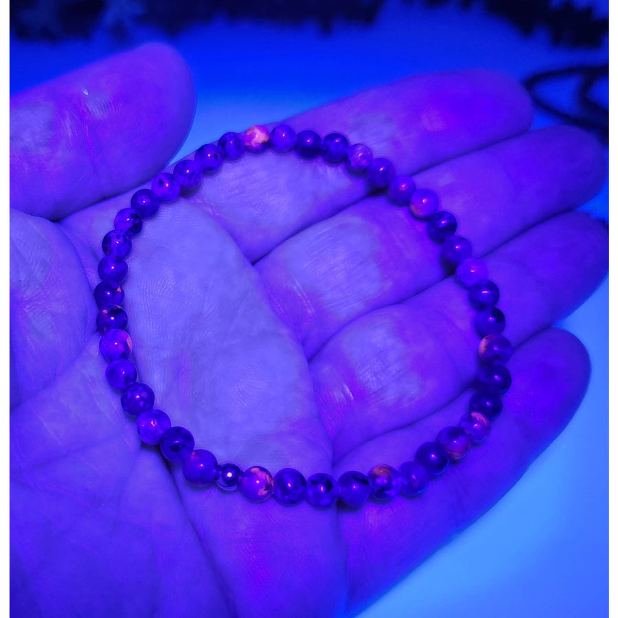 Purple beaded Yooperlite bracelet with orange glass accents, UV reactive