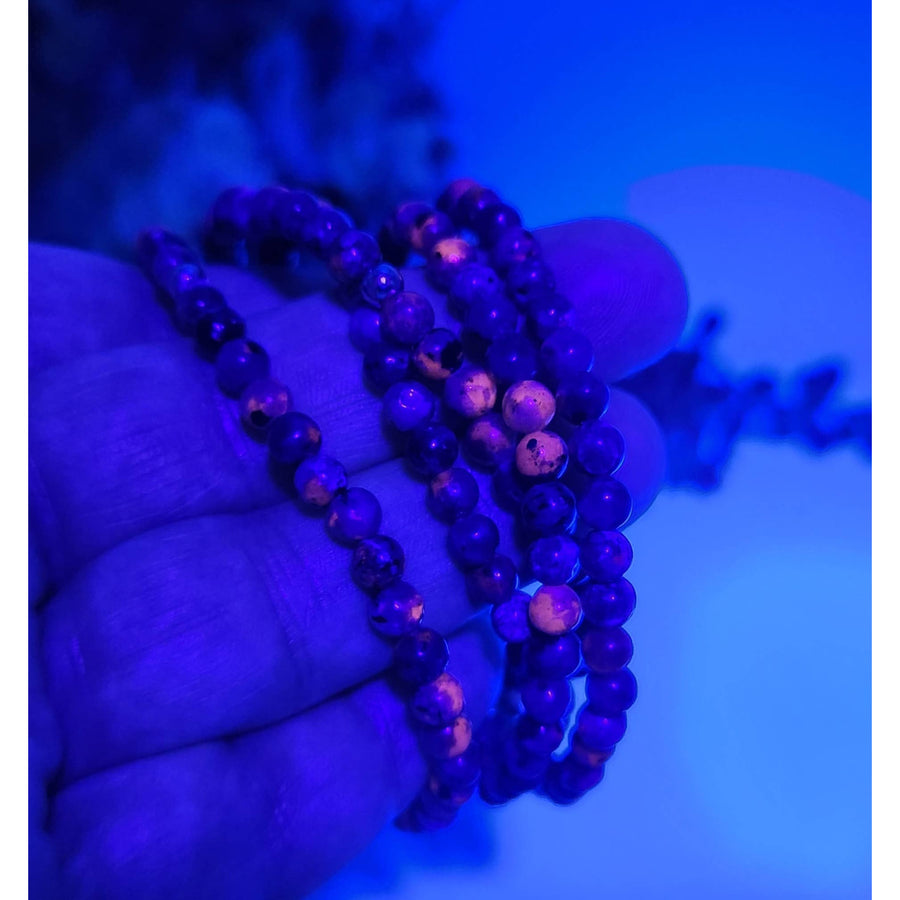 Purple Yooperlite UV-reactive 4mm beaded stretch bracelet with wooden beads