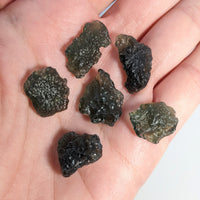 Thumbnail for 6 rough-cut moldavite crystals in the palm of the hand