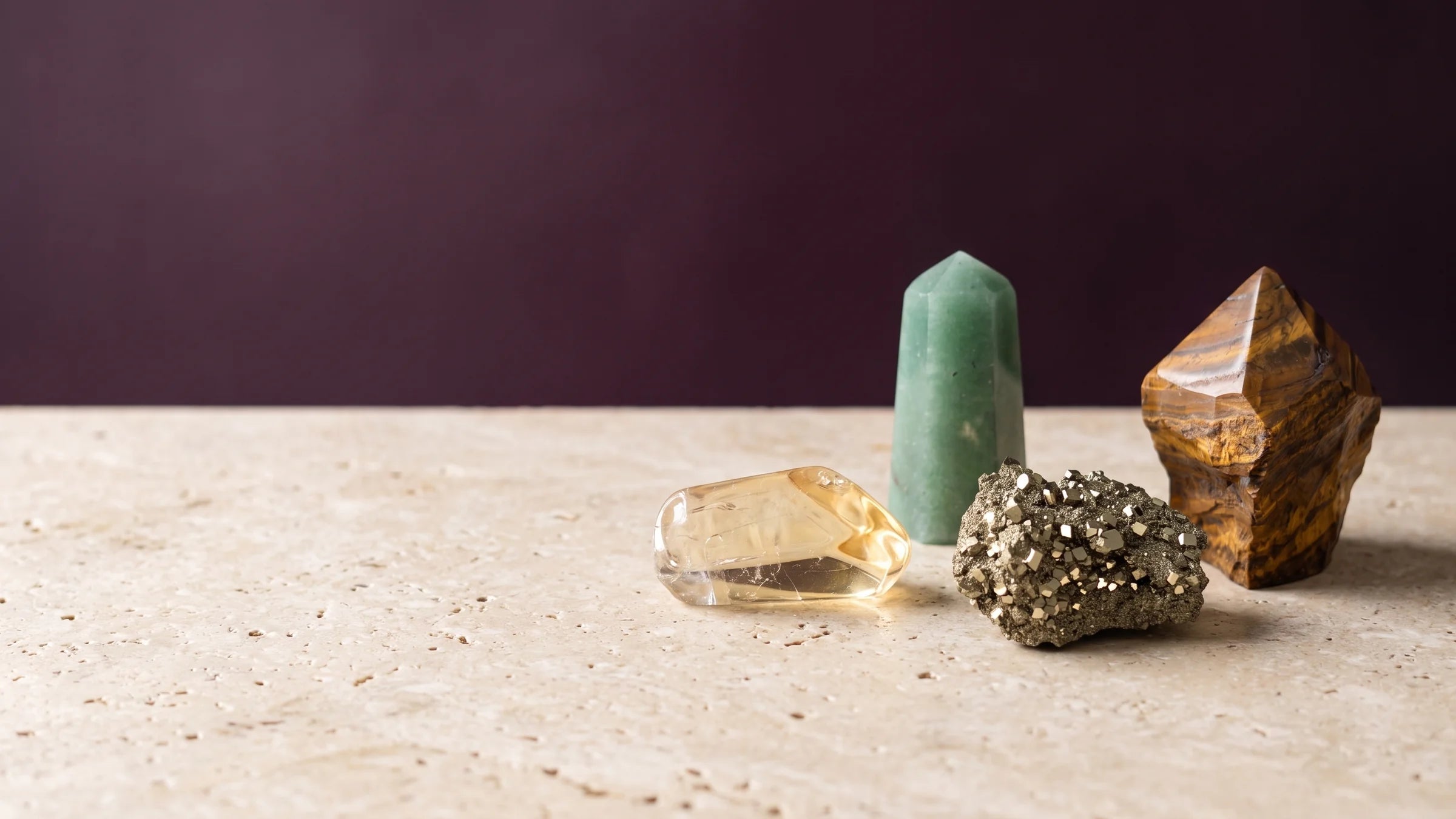 Citrine, pyrite, green aventurine and tiger's eye grouped in warm studio light.