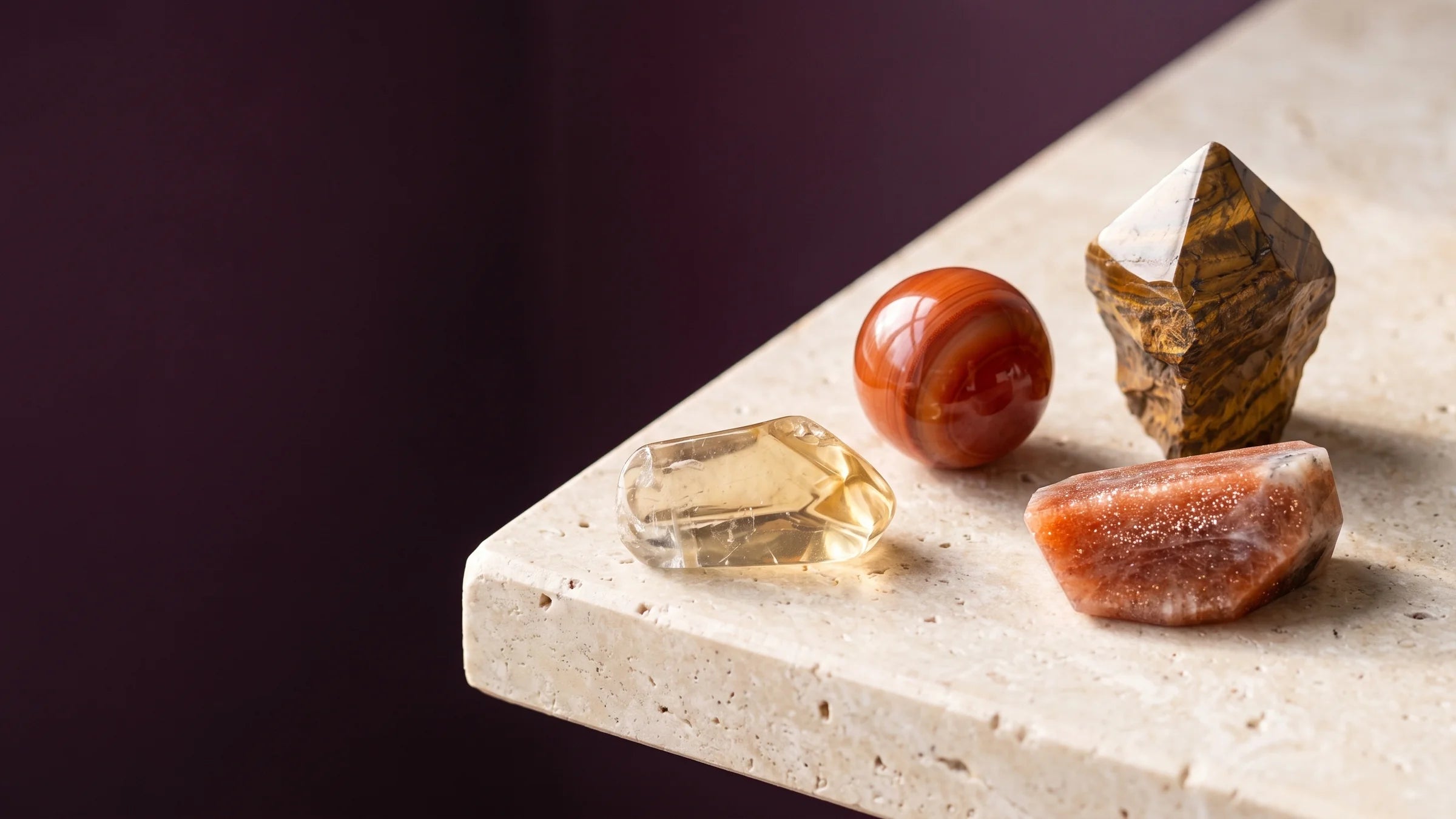 Citrine, golden tiger's eye, carnelian and sunstone in warm studio light.